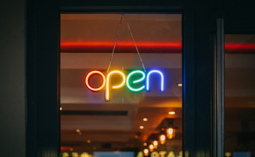 door to a restaurant or bar with a neon sign saying OPEN